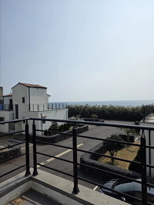 View from villa terrace — ocean and townhouse exterior