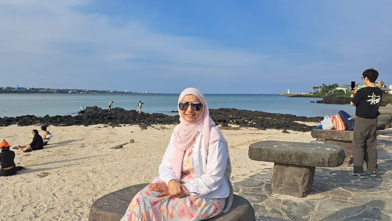 A guest sitting on the basalt rocks at the water's edge