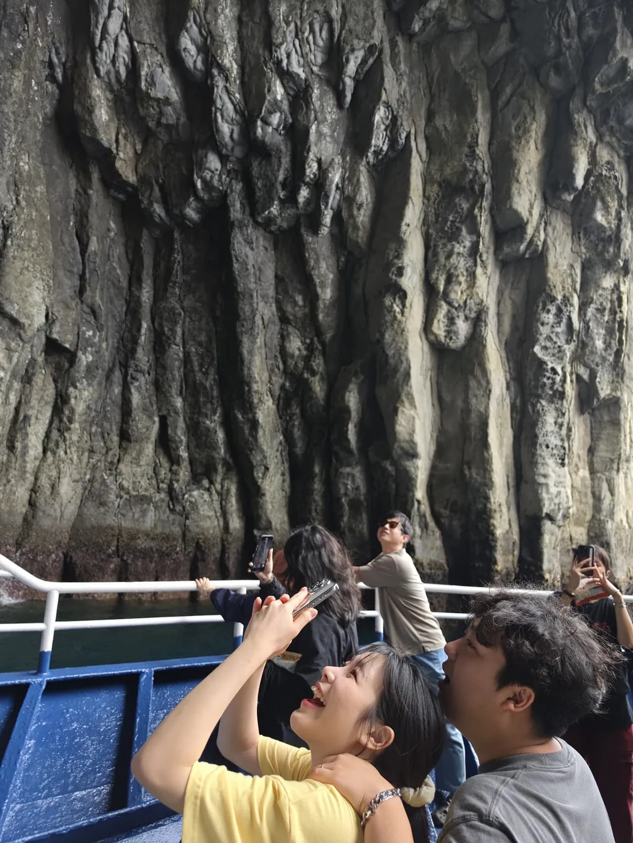 Guests photographing the columnar cliffs from the boat deck