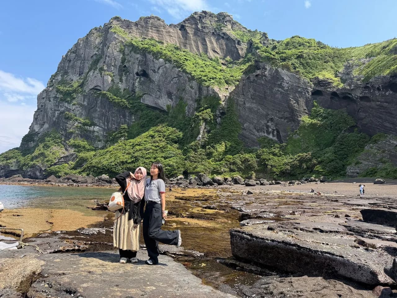 Two guests posing on the rocks below Seongsan Ilchulbong's tuff cone
